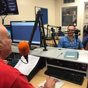 A podcast host sits opposite a guest speaker.