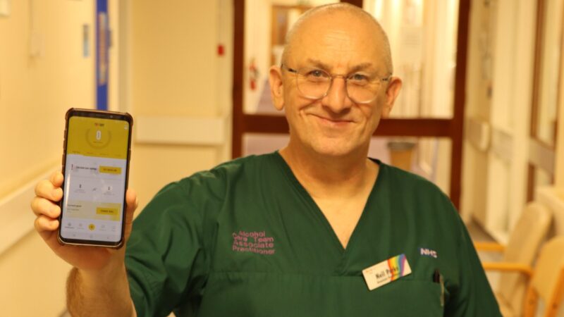 Alcohol care nurse stands in corridor holding dry January app.