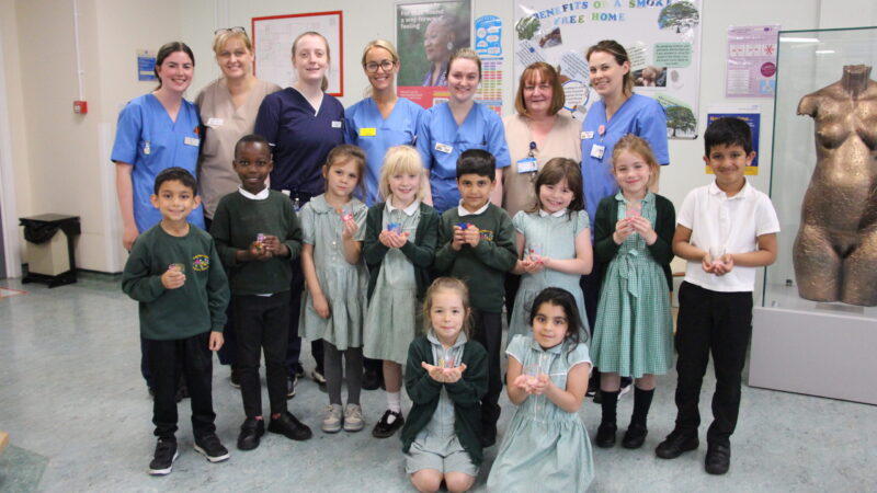 Children from Oxbridge Lane, their tealight gifts and midwives from the unit.