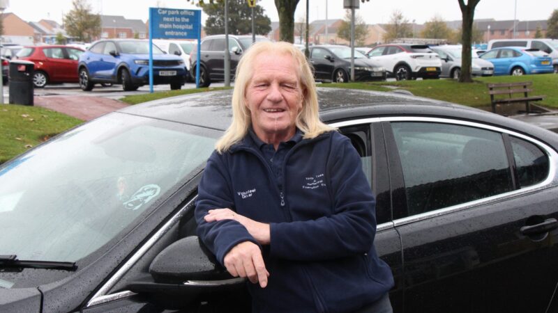 Robbie Earl leans on a car.